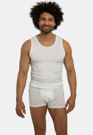 Hvid bomulds tanktop og boxershorts på en smilende mand, der fremviser et tætsiddende design med en glat tekstur uden mønstre.