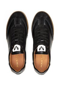 Baskets en suède et cuir noir avec des lacets noirs, des semelles en caoutchouc beige, des accents perforés et une étiquette logo sur la languette.