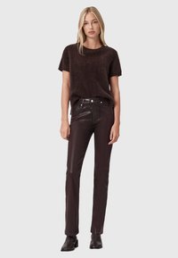 Maglione corto a maniche corte in maglia marrone pelosa abbinato a pantaloni in pelle marrone scuro e stivaletti alla caviglia. Design semplice con vestibilità comoda.