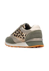 Zapatilla verde y beige con detalle de estampado de leopardo, materiales de ante y cuero texturizados, suela gruesa con acentos naranjas y tacón metálico.