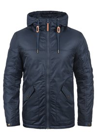 Giacca con cappuccio blu navy, dotata di zip frontale, cordini con dettagli in pelle, tasche a patta con bottoni a pressione e tasca con zip sulla manica sinistra.