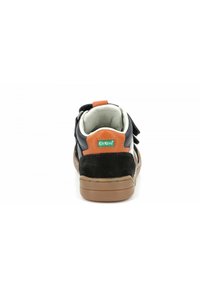 Sneaker nera in suede e pelle con un accento arancione sul tallone e un rivestimento bianco imbottito, dotata di suola in gomma e fascia regolabile.