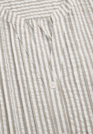 Striped shirt in beige and white with a V-neckline, featuring a front pleat and a white button. Lightweight fabric with a wrinkled texture.