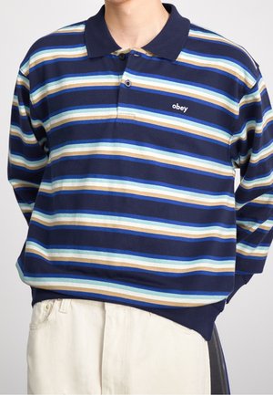 Granatowa koszulka polo w paski z poziomymi paskami w kolorze niebieskim, jasnoniebieskim i beżowym. Zawiera kołnierzyk oraz wyszywane logo "obey".