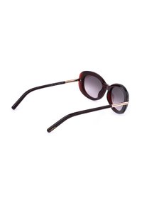 Lunettes de soleil ovales brun foncé avec verres dégradés et branches fines avec accents dorés et marquage « Furla » sur une branche.