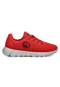 Chaussure de sport rouge avec une tige en tissu texturé, semelle en caoutchouc grise, lacets plats et logo noir sur le côté.
