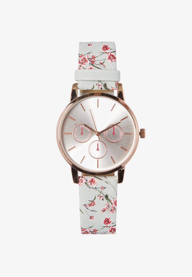 Rund sølvklokke med tre sub-dialer og rosegulldetaljer. Hvit stoffrem med blomsterdesign og teksturert overflate.