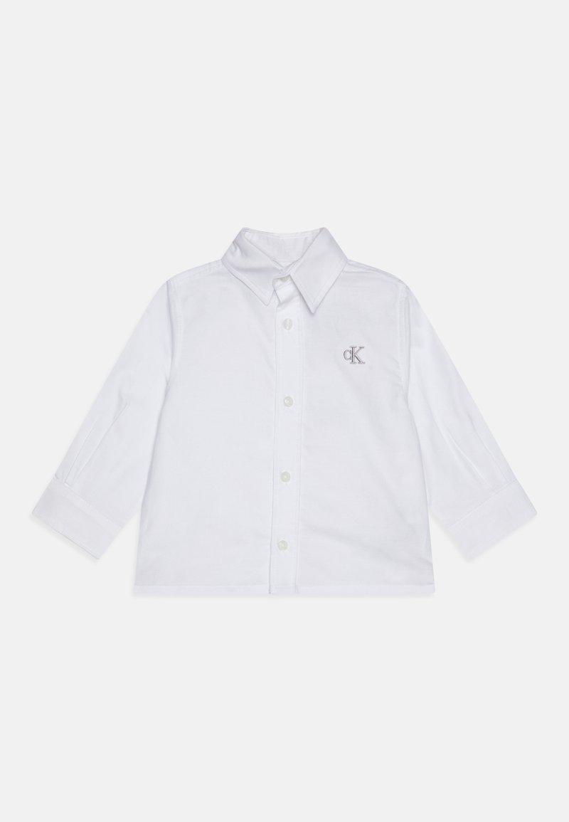 Maglietta bianca a maniche lunghe con colletto a bottoni, caratterizzata da ricamo del logo 'CK' in argento sul lato sinistro del petto e chiusura a bottoni.