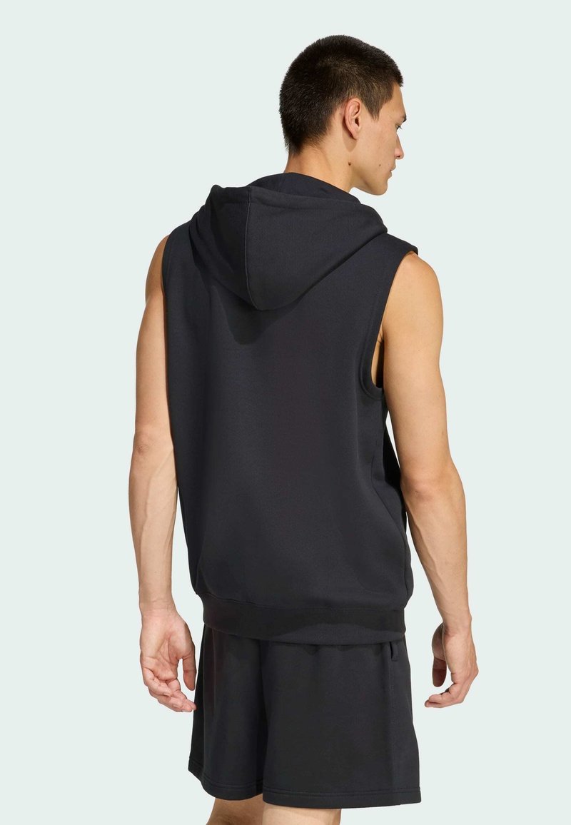 Black sleeveless hoodie made of soft fabric, featuring a drawstring hood, ribbed hem, and a relaxed fit, paired with matching shorts.