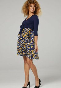 Navy dress with floral print in yellow and white; fitted bodice with wrap design and bow detail; flared, knee-length skirt; three-quarter sleeves.