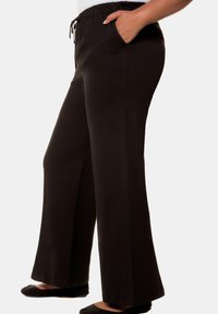 Schwarze, weit geschnittene Hose mit einem Kordelzugbund und seitlichen Taschen, aus weichem, leichtem Stoff mit einer glatten Textur.