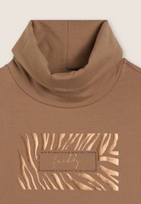 Maglione a collo alto marrone con motivo a strisce zebrato in rilievo e un accento metallico al centro. Materiale morbido e elastico.