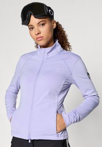 Svetlofialová bunda na zips s vysokým golierom, vybavená bočnými vreckami a s kontrastným prešívaním a logom na rukáve.