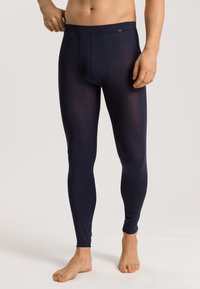 Leggings navy en tissu lisse et extensible, présentant une coupe ajustée et une taille confortable, avec un détail de couture subtil à l'avant.