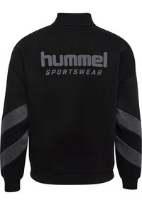 Felpa sportiva nera con colletto alto, caratterizzata da un logo grigio "hummel SPORTSWEAR" sulla schiena e strisce diagonali grigie sulle maniche.