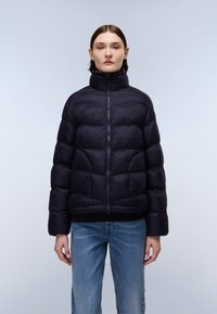 Giacca a vento blu navy con colletto alto, dotata di chiusura con zip e design trapuntato. Tessuto morbido e liscio con orlo inferiore elasticizzato.