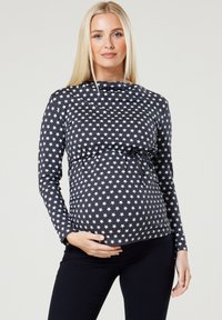 Langärmliges Umstandoberteil in Marineblau mit weißem Sternenmuster, mit gerafftem Bund und Bindegurt für eine verstellbare Passform. Weicher, dehnbarer Stoff.