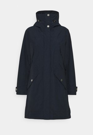 Long manteau imperméable bleu marine foncé avec col haut, boutons pression, cordons de capuche réglables, poches à rabat et sangles aux poignets.