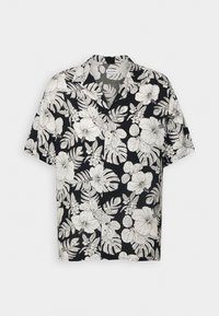 Chemise noire à manches courtes boutonnée avec motif blanc floral et feuilles tropicales.