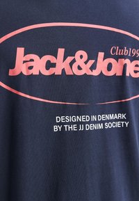 Navy T-Shirt mit pinkem Grafiktext "Jack & Jones" und "DESIGNED IN DENMARK BY THE JJ DENIM SOCIETY." Weicher Baumwollstoff.