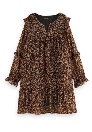 Ein junges Mädchen trägt ein braun-schwarzes, langärmliges Blumenmusterkleid, kombiniert mit schwarzen Schnürknöchelstiefeln und hellen Socken.