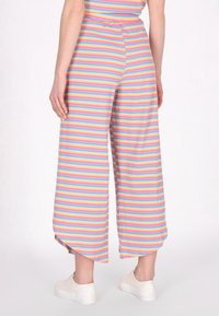 Gestreepte wijde broek met pastelkleuren, een ontspannen pasvorm en een zachte ribbelstructuur. Aangevuld met zijsplitten aan de zoom.