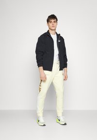 Nike Sportswear Calças de fato de treino - coconut milk/white/dark driftwood