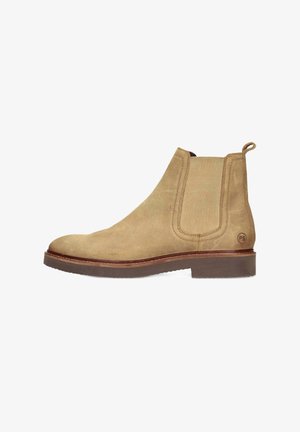 Beige suède Chelsea boot met elastische zijpanelen, een trekhaak en een rubberen zool. Heeft een contrasterende bruine rand rond de basis.