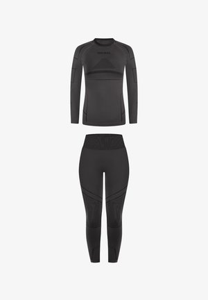 Schwarzes, figurbetontes Sportoutfit bestehend aus einem langärmligen Oberteil mit strukturierten Akzenten und hoch taillierten Leggings mit nahtlosem Design und geometrischen Mustern.