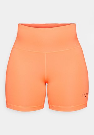High-waisted athletic shorts in bright orange, made from smooth, stretchy fabric. Features contrasting stitching and a logo on the left leg.