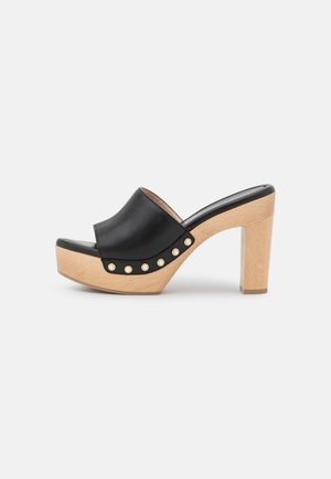 Black leather open-toe mule with natural wooden platform heel and gold-studded detailing along the sole edge.