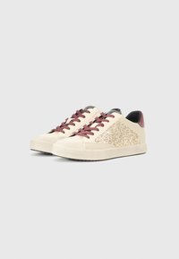 Sneakers beige con un accento glitterato dorato di lato, lacci bordeaux e un tallone nero a contrasto, con suola in gomma.