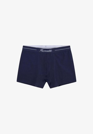 Boxer in cotone blu navy con vestibilità aderente. Presenta un elastico grigio con strisce bianche e il logo "Faconnable". Tessuto morbido.