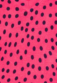 Maglione a maglia rosa con scollatura a V, decorato con pois blu scuro equidistanti su tutta la superficie del tessuto. Texture liscia.