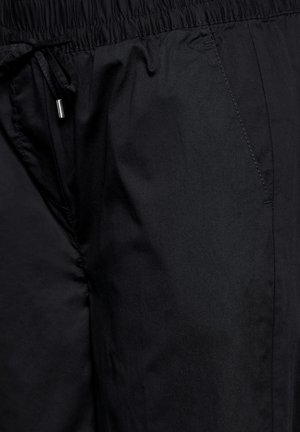Zwarte lichte shorts met een elastische tailleband, verstelbaar trekkoord en een soepele textuur. Bevat naaddetails aan de zijkanten.