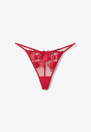 Czerwony koronkowy string z kwiatowym haftem z przodu, z przezroczystymi panelami siateczkowymi i solidnym materiałem z tyłu. Regulowane paski dopełniają całość.