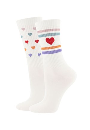 White crew socks with colorful hearts; one sock has scattered small hearts, the other a large red heart with pastel stripes.