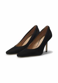 Scarpe con tacco alto in suede nero, punta a punta, lati profondamente tagliati e tacco a stiletto sottile. Fodera interna liscia, dettagli hardware minimalisti.