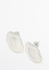 Orecchini a post con perno in argento dal design irregolare e texture, caratterizzati da una superficie liscia e lucida e da un'estetica minimalista.