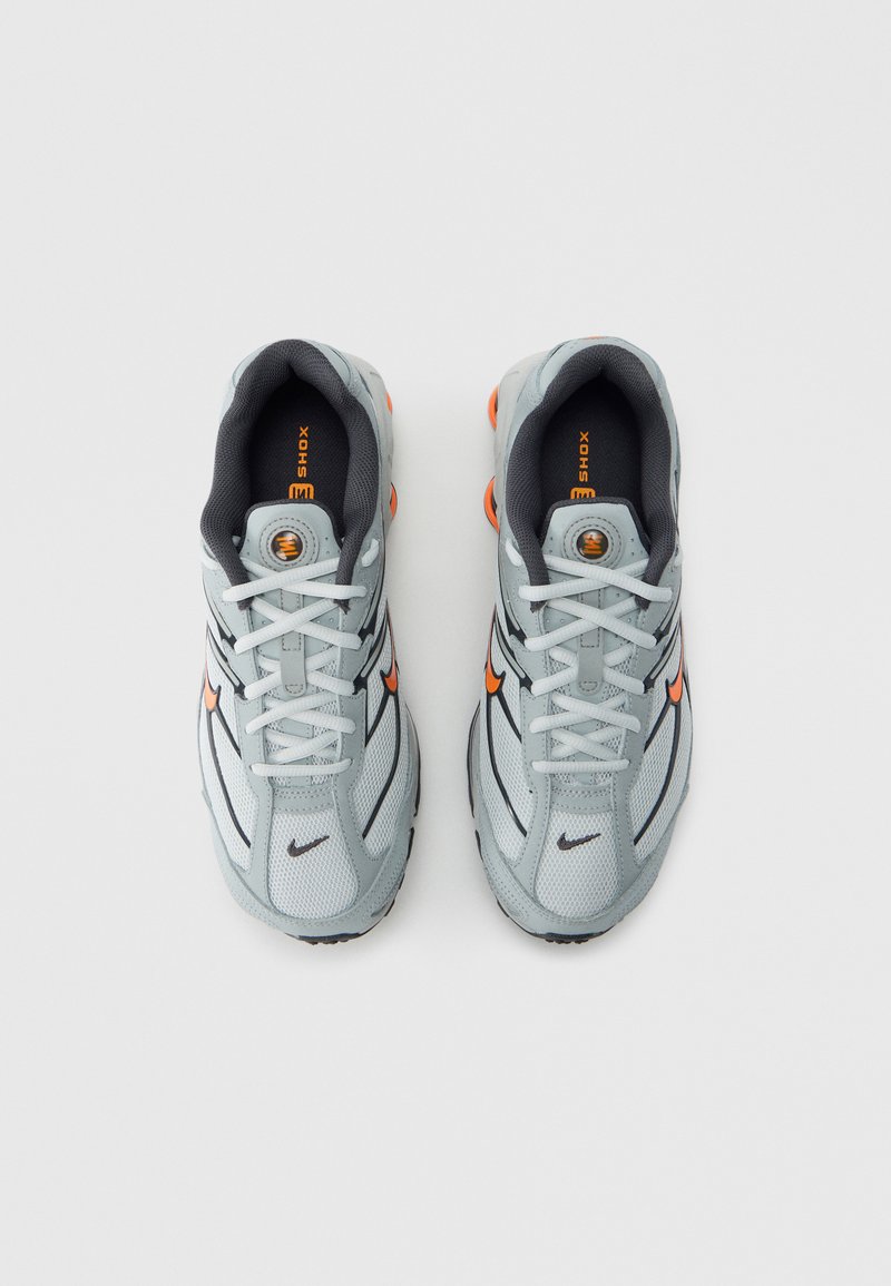 Gray mesh athletic shoes with black accents and orange detailing. Features white laces and a padded collar. Rubber sole with visible shock absorbers.