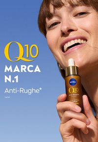 Bottiglia di vetro marrone con pipetta, etichettata "Q10 Esperto Anti-Rughe" in testo giallo e bianco. Sfondo di cielo blu senza nuvole.