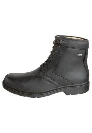 Schwarzer Lederankleboot mit abgerundetem Zehenbereich, Schnürdesign und sichtbaren Nähten. Verfügt über ein Gore-Tex-Logo und eine strukturierte Oberfläche.