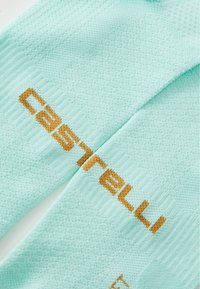 Calcetines de ciclismo de color azul claro, confeccionados en tela texturizada, con la marca "Castelli" en tonos amarillo-marrón tejida en el diseño.