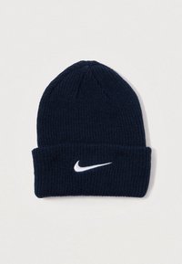 Gorro de malha azul-marinho com uma aba dobrada, apresentando um logótipo branco da Nike. Feito de tecido texturizado para aquecimento e conforto.