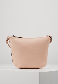 Růžová kožená crossbody kabelka s texturovaným povrchem, zaobleným tvarem a zapínáním na zip. Obsahuje odnímatelný popruh a minimální kovové doplňky.