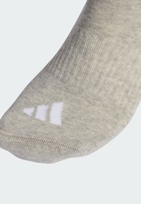 Světlé šedé ponožky s texturovaným pleteným vzorem a zesílenou špičkou, s třemi bílými pruhy na boku jako značka.