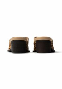 Ζευγάρι παπούτσια slip-on με λεοπάρ σχέδιο, μπεζ επένδυση και στρωτούς μαύρους τακούνια, εμφανιζόμενα από πίσω σε λευκό φόντο.