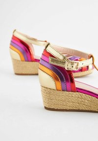 Skopumper med kilehæle og multikolorede metalliske striber i pink, lilla, orange og guld, prydet med en flettet jute platform og ankelrem.