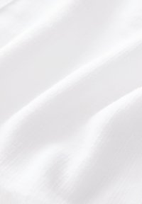 Tessuto bianco con una superficie liscia e una leggera lucentezza, caratterizzato da pieghe morbide e un aspetto leggero.