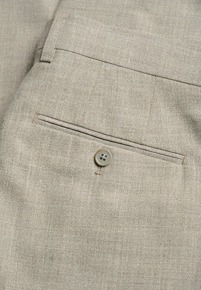 Beżowe spodnie z materiału z tylną kieszenią, okrągłym, czterodziurkowym guzikiem oraz subtelnym, strukturalnym wzorem na całej powierzchni.